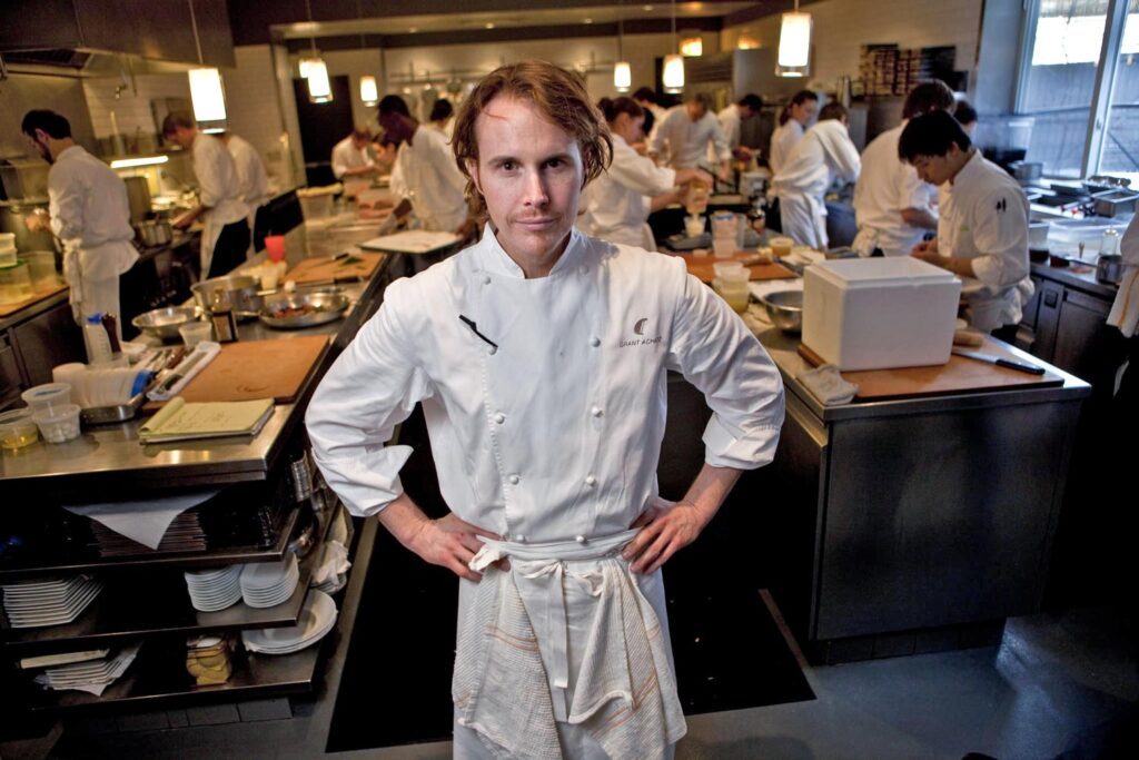 Prato sofisticado sendo servido em um restaurante de alta gastronomia, inspirado no Alinea Restaurant