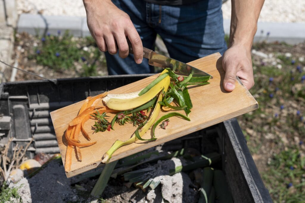 Funcionário de restaurante utilizando um triturador de lixo orgânico na cozinha
